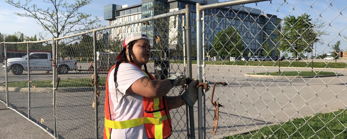 Installer securing chain link fence on a job site