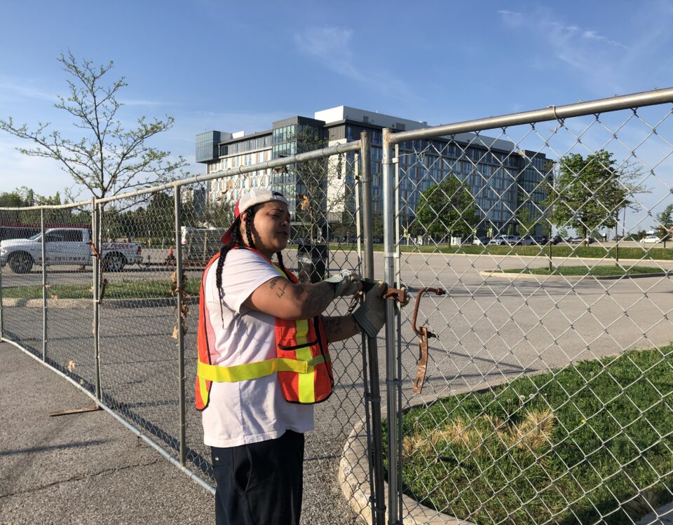 Installer securing chain link fence on a job site